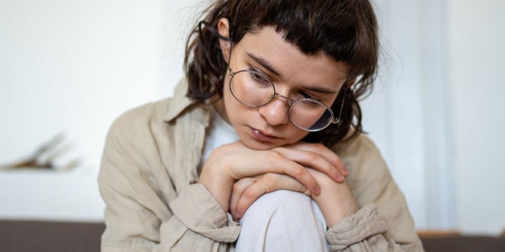 Junge Frau schaut nachdenklich – Symbolbild für den Online-Selbsttest bei Depression