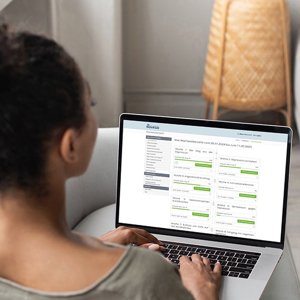 Frau bearbeitet auf Ihrem Laptop das Novego Online-Therapieprogramm bei Depression.