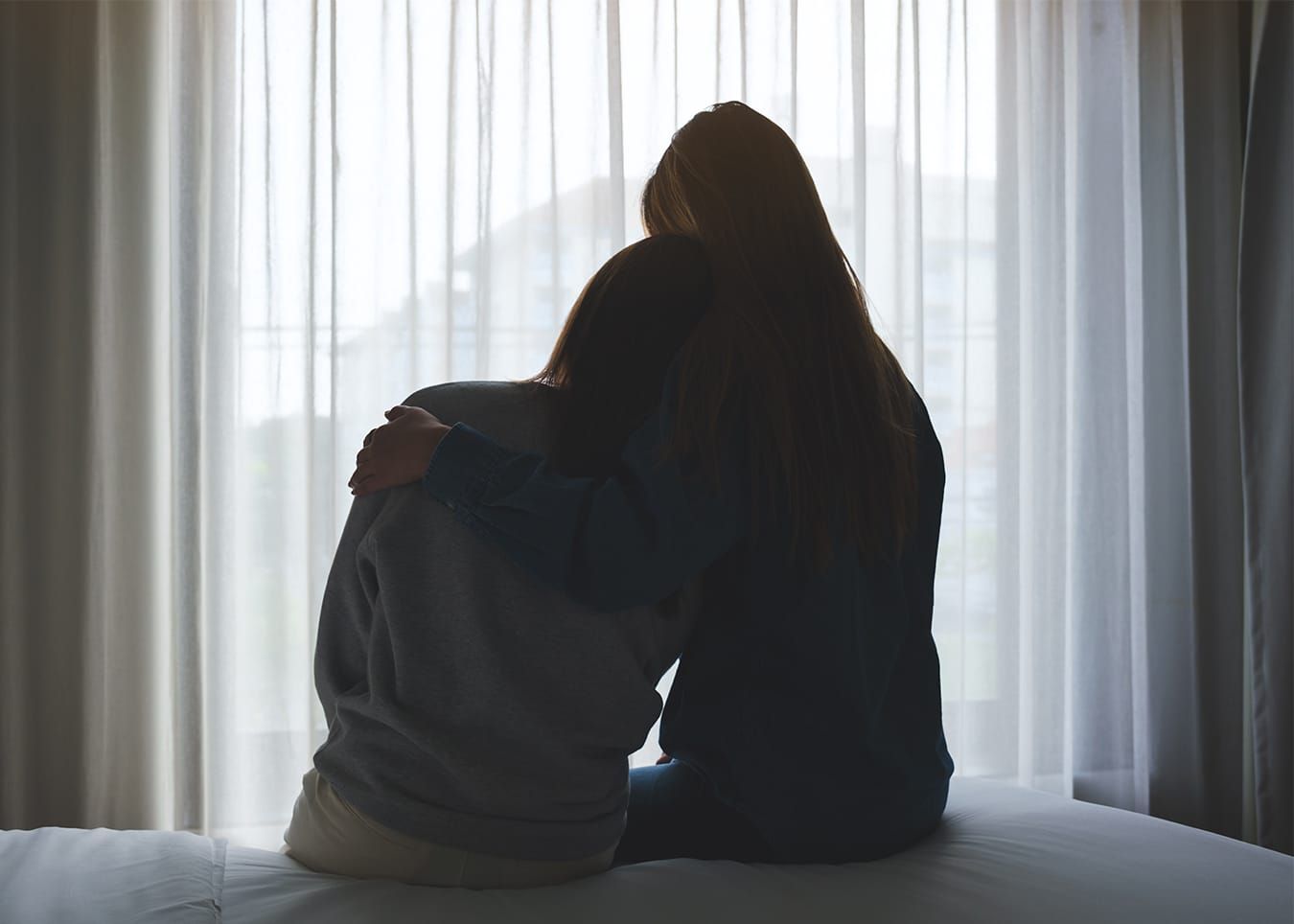 Entspannte Frau auf Sofa mit Laptop, daneben zeigt ein Smartphone das Novego Online-Therapieprogramm mit erwiesener Wirksamkeit bei Depression und Angst nach 6 bis 12 Wochen.